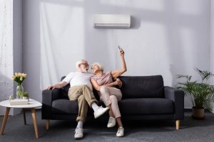 couple-on-couch-in-front-of-ductless-air-handler